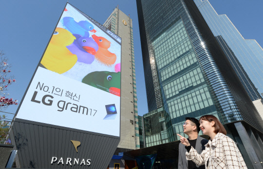 모델들이 서울 삼성동에 위치한 파르나스 호텔 앞에서 LG전자가 설치한 고화질의 초대형 LG LED 사이니지를 소개하고 있다.  LG전자 제공